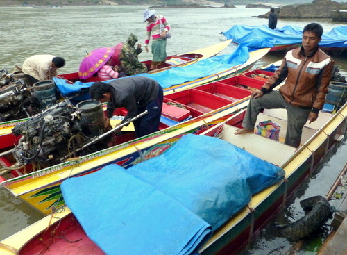 Driver speedboat di sungai Mekong sedang mengisi bahan bakar
