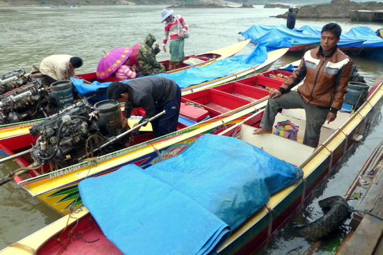 Driver speedboat di sungai Mekong sedang mengisi bahan bakar