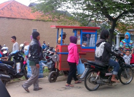 A man sells ice cream to the gathered crowd